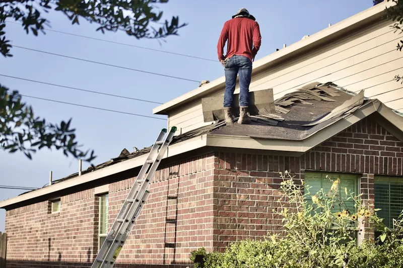 Professional roofer working on a residential roof in Cadillac